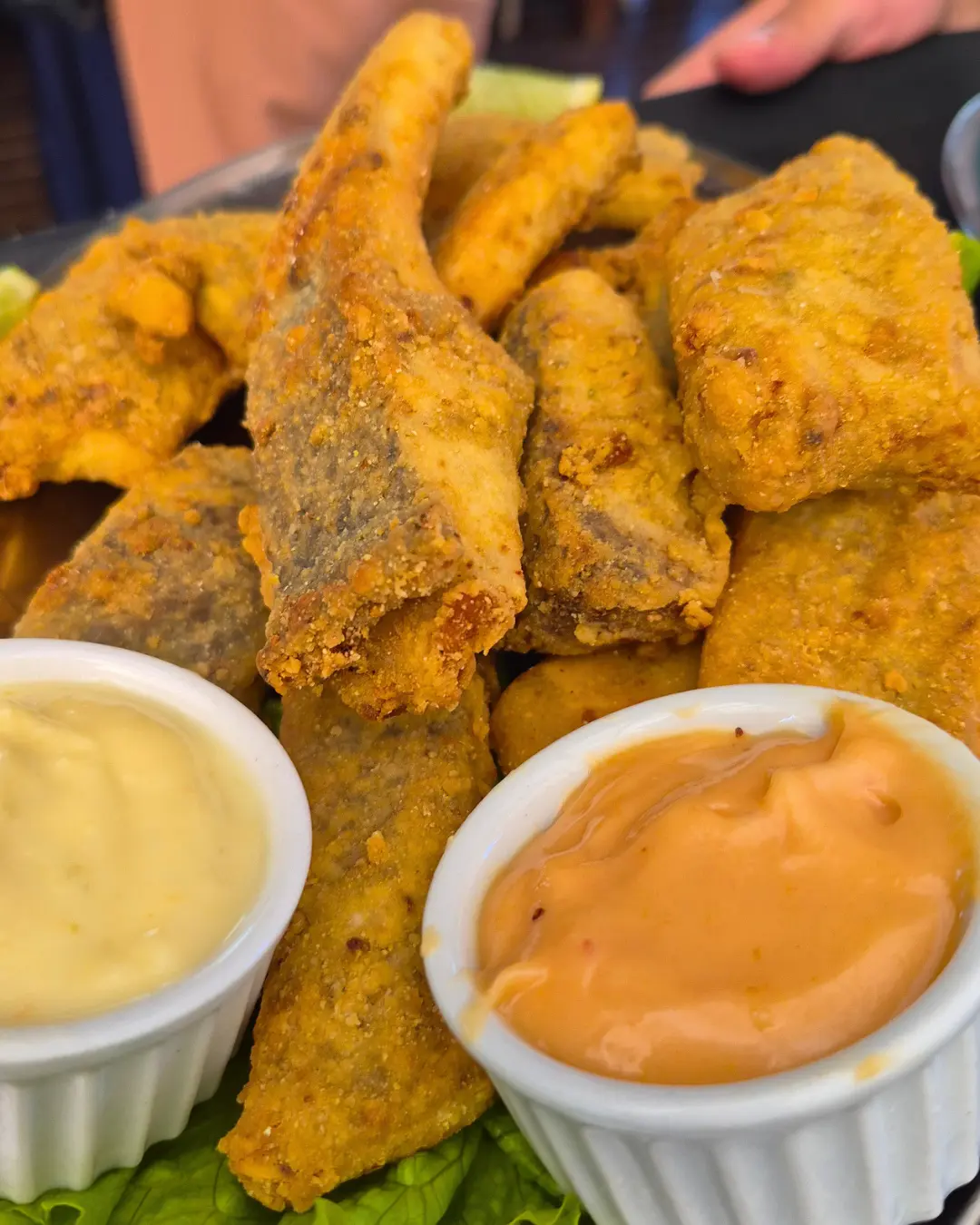 Porção de peixe com molhos da casa