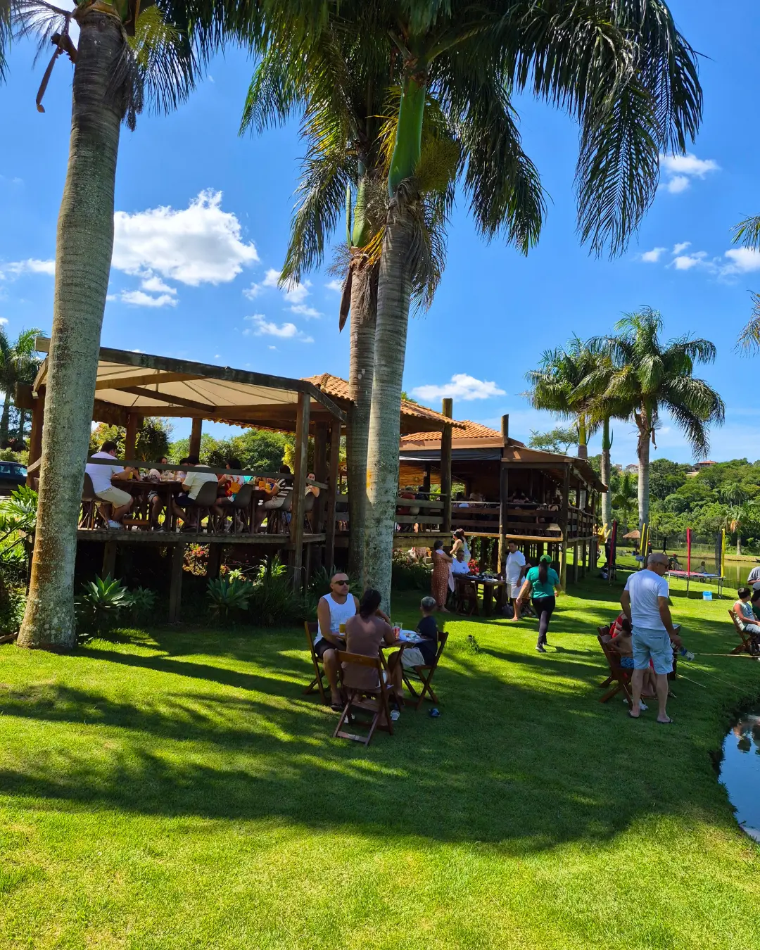 Área externa do restaurante com mesas no gramado