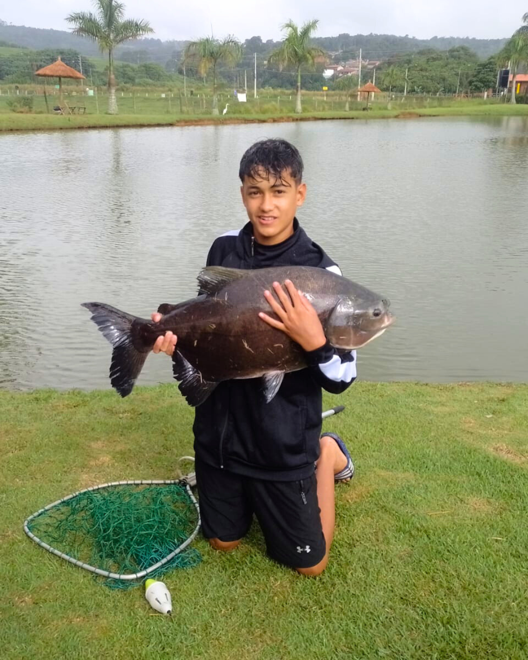 Jovem pescador com tambaqui capturado no lago